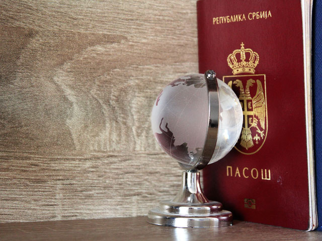 Serbian passport next to a globe