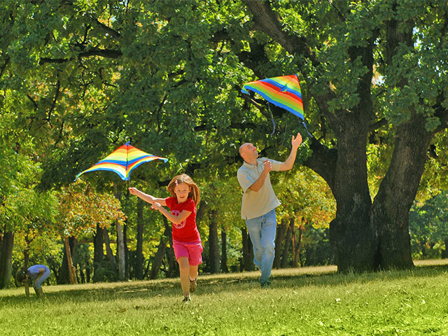 Girl and her father kite running in the park