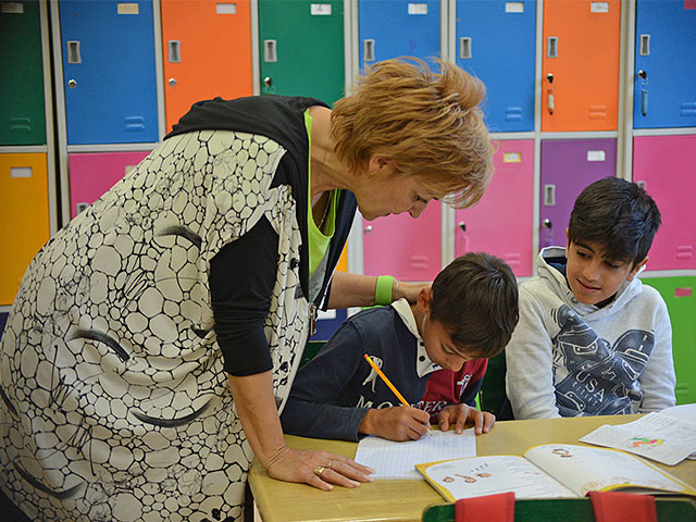 Учитељица помаже ученицима при решавању задатака